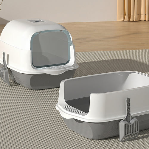 Two cat litter boxes on a wooden floor.