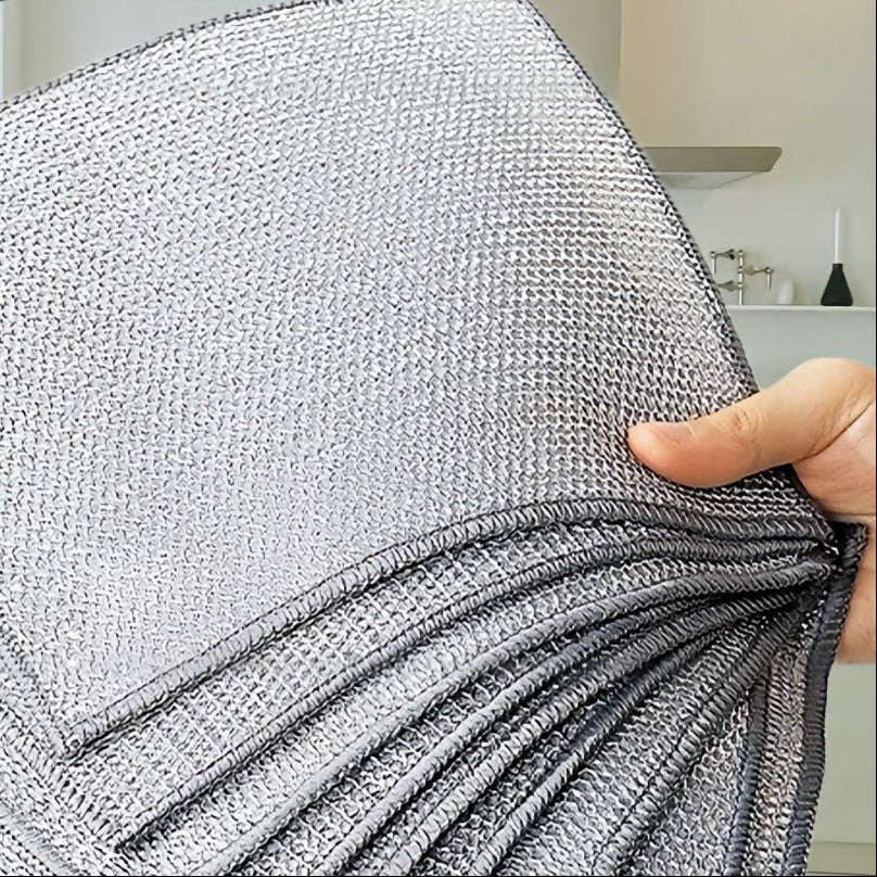 Stack of metal mesh cleaning cloths held by a hand with text overlay in a room setting.
