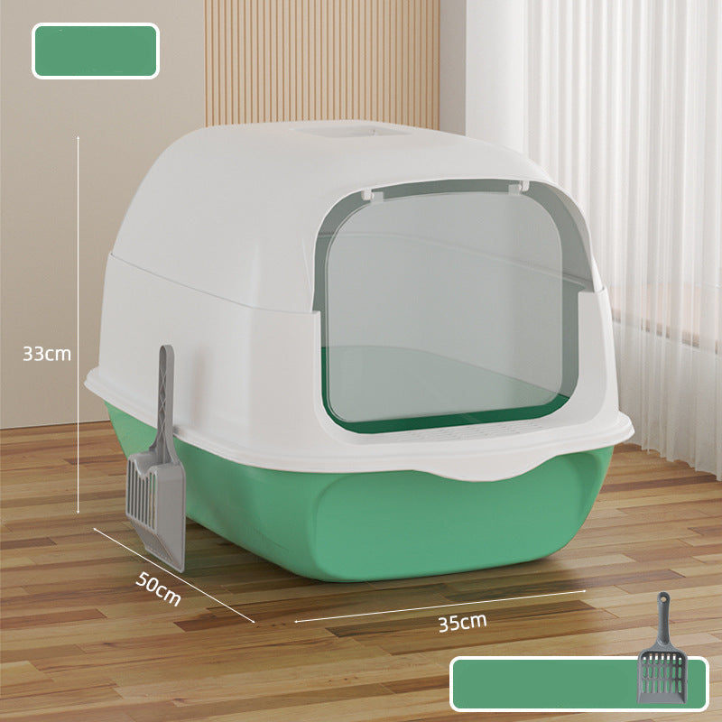 Green and white pet litter box with dimensions on a wooden floor.